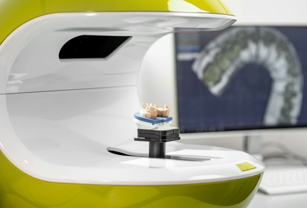 Modern dental imaging equipment with monitor displaying X-ray scan in professional orthodontic office.